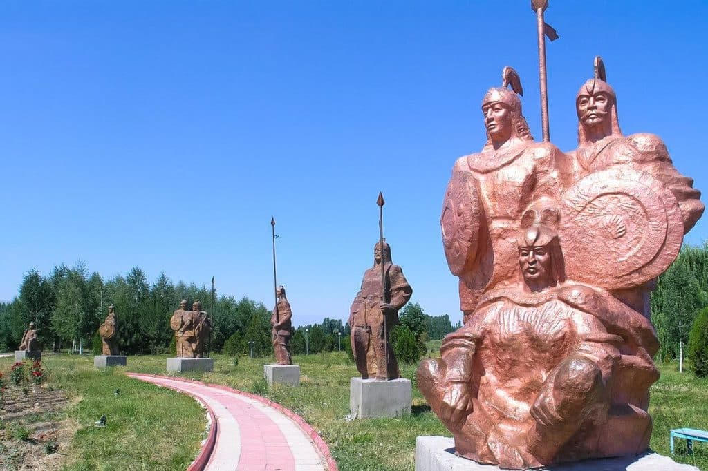 Manas-Gefährten um seine Statue im Manas Ordo in Talas